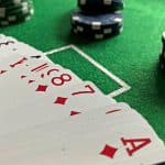 Close-up view of poker cards and chips on a green felt table, perfect for casino-themed content.